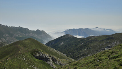 landscape with mountains, fog and blue sky