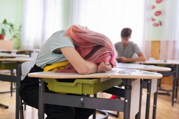 Tired girl teenage student asleep on her desk