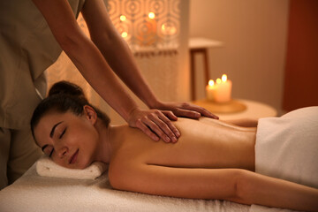 Fototapeta na wymiar Young woman receiving back massage in spa salon