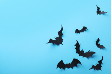 Paper bats on light blue background, flat lay with space for text. Halloween decor
