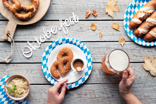 Celebrating Oktoberfest alone. Traditional food and beer, leberkase and pretzels.Text Oktiberfest.