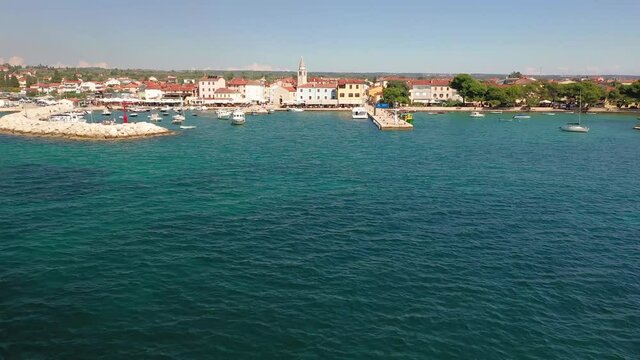 Fly towards the harbor of the historic town Fazana in Croatia during daytime