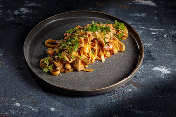 Fettuccine pasta with bacon or meat is on the plate