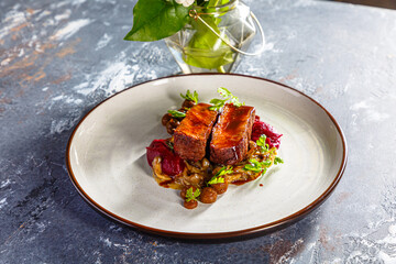 Grilled beef with mushrooms, mashed potatoes and beetroot sauce is on the plate