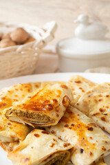 Pancakes filled with meat stuffing on a white plate, rolled pancakes
