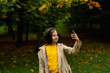 season and people concept .happy girl taking selfie at autumn park
