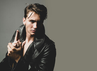 Sexy man with finger gun gesture isolated on grey background isolated.