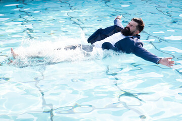 Summer business. Businessman with a suit swimming in the pool.