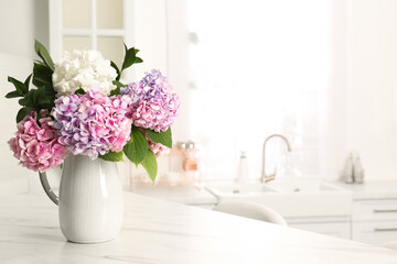 Bouquet with beautiful hydrangea flowers on white marble table. Space for text