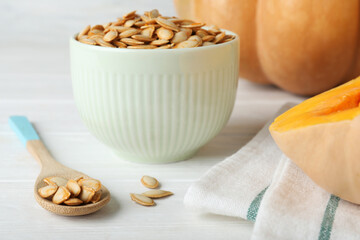 Raw pumpkin seeds on white table, closeup