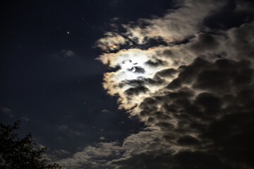A shot of the cloudy moon. Some stars can be seen.