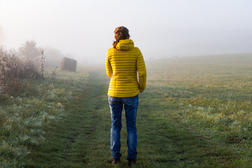 woman walking alone in autumn landscape  social distancing