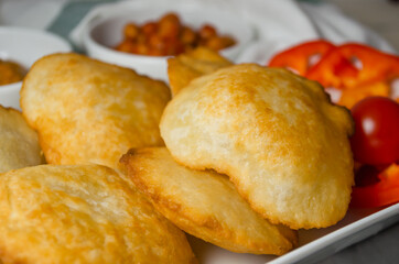 Indian cuisine. Luchi tortillas with cooked and fresh vegetables.