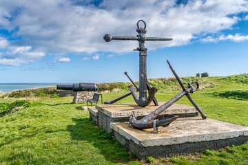 Old naval fortifications, cannon and rusty anchor as landmark and tourist attraction in Wicklow port and village, Ireland