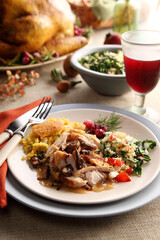 A healthy and delicious holiday thanksgiving turkey dinner plate on an ornate table with wine.