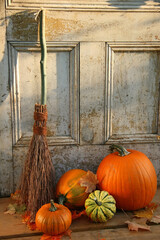Pumpkin and gourds with old broom at the door