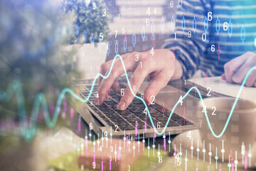 Double exposure of woman hands typing on computer and forex chart hologram drawing. Stock market...