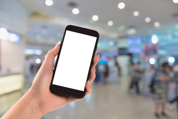 Hand holding smartphone with white blank screen on blurred exhibition hall.