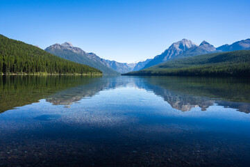 Calm Lake Bowman with a Reflection of Mountains in the Background in Northern Glacier National Park