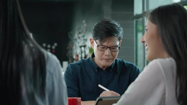Happy Business man asian sitting in meeting with Team Business people to work happy with smile In modern office. New normal working agreement. Doctor Talking and consultation between people