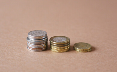 stacks of different coins on brown background