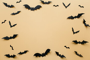 Halloween decorations with bats on pastel beige background. Halloween concept. Flat lay, top view, copy space