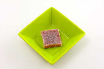 Prickly pear cactus jelly gummy candy square in small green candy bowl on white background
