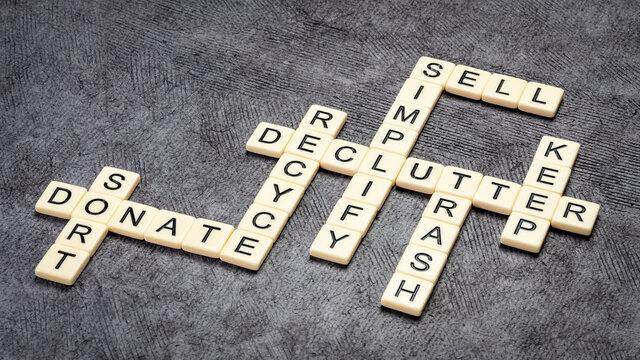 declutter concept - simplify, sort, sell, donate, trash, recycle, keep - crossword with ivory letter blocks against black textured paper, minimalism and personal development
