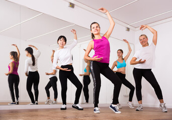 Fototapeta na wymiar Women dancing aerobics at lesson in the dance class. High quality photo