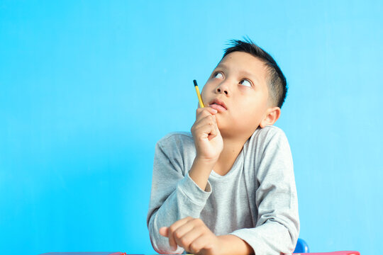 little boy thingking while studying. happy and smart child is looking for an idea.