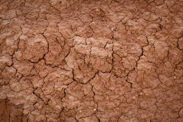Top view cracked red soil. Picture of natural disaster. Drought land, global warming and deforestation. Image of brown soil texture, close up. Desert realistic background.