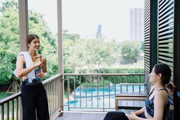 Fototapeta premium Beautiful women talking with friend at balcony after exercising together.