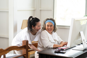 Happy Asian senior mother and daughter making video call conference camera and talking with family.Video chat social distancing.