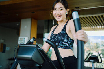 Beautiful healthy woman exercising on gym bike indoors.