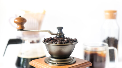 Coffee set, fresh roasted coffee beans in the mill manual coffee grinder and glass bottle black coffee paper drip isolated white background