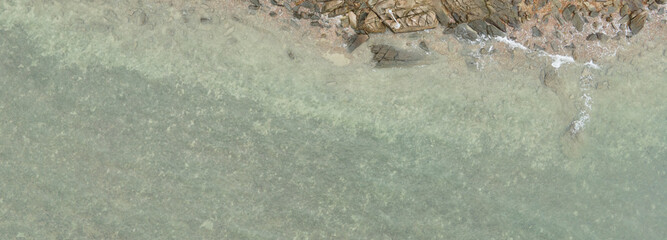 Bird's eye view, beach rocks on a bright summer day, aerial view drone shot..