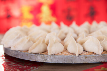 Fototapeta na wymiar Pack the festive dumplings to be cooked in front of a festive red background