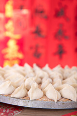 Pack the festive dumplings to be cooked in front of a festive red background