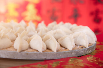 Fototapeta na wymiar Pack the festive dumplings to be cooked in front of a festive red background