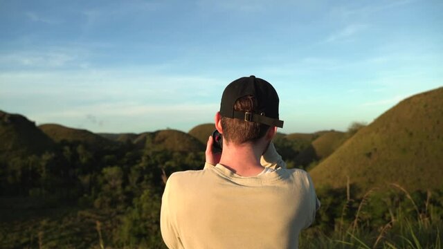 Photographer taking pictures of amazing view over the chocolate hills in south east Asia - Philippines