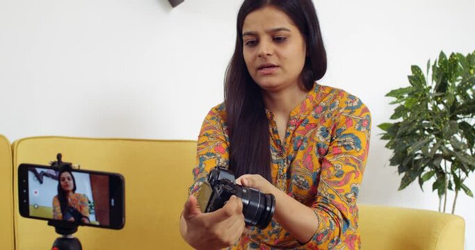 Young woman recording video of herself at home for social media vlog influencer product meeting video call via smart mobile device live product latest camera review analysis critic tech to followers 