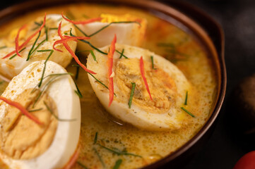 Egg green curry in black cups.