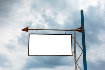 Old empty billboard for advertising poster with arrow sign on the background of  rainy cloudy sky.