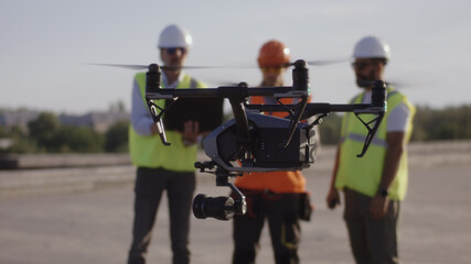 Drone flying near male builders