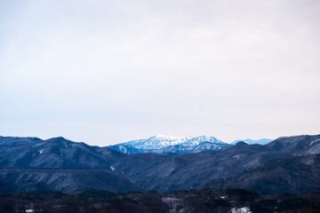 Fototapeta na wymiar Landscape of big mountain range with snow on top in winter view from Kusatsu Onsen, Japan