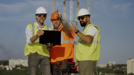 Builders using laptop on construction site