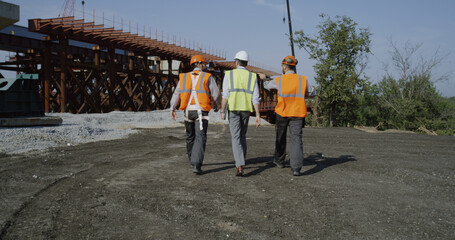 Fototapeta premium Professional engineers walking towards unfinished bridge
