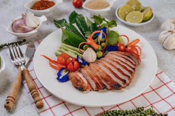 Sliced ​​fried pork with lemon, onion, red onion, tomato, long bean, butterfly pea flower, and mint.
