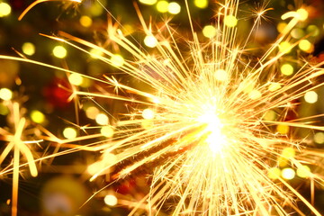 Bengal light.Sparkler sparks.Christmas and new year festive background. Bengal fire on a festive Christmas tree on blurred background.Winter holidays beautiful background.