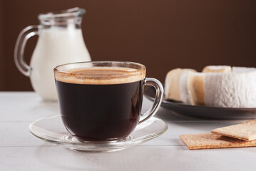 Tasty breackfast with a cup of hot american black coffee and creamy Camembert cheese on natural white wooden table.